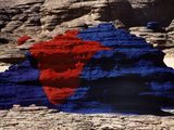 une image représentant un drapeau rouge et bleu posé sur un rocher