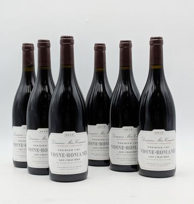 six bouteilles de vin sont alignées sur une surface blanche