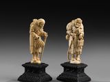 a pair of carved ivory figurines of a man and a woman