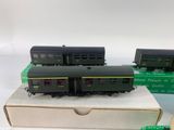 two black and green train cars sitting on top of a box
