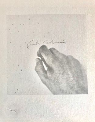 une vieille photo en noir et blanc représentant une main tenant un morceau de papier