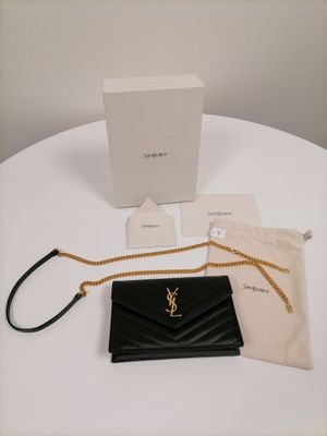 the saint laurent wallet bag is sitting on a table next to a box