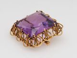 a close up of a purple stone in a gold ring
