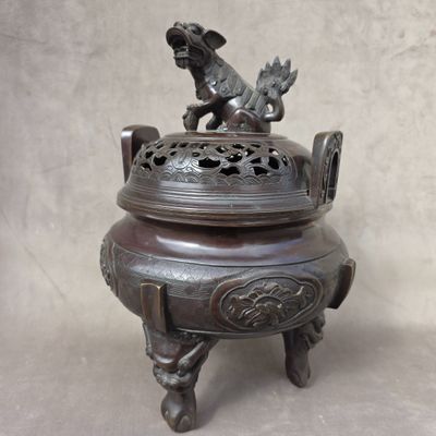 a bronze incense box with a dog on it
