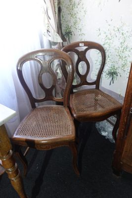 deux chaises en bois assises l'une à côté de l'autre dans une pièce