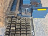 une machine posée par terre à côté d'un tas de briques