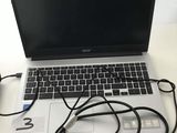 a laptop that is sitting on a desk with a charger on it