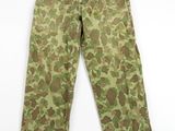un gros plan d'un pantalon de camouflage sur fond blanc