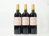 trois bouteilles de vin rouge sont posées sur une surface blanche