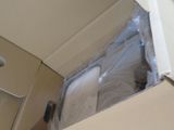 a box with a toilet in it that is wrapped in plastic