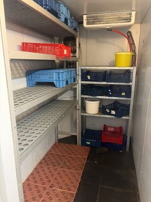 a small room with shelves and bins in it