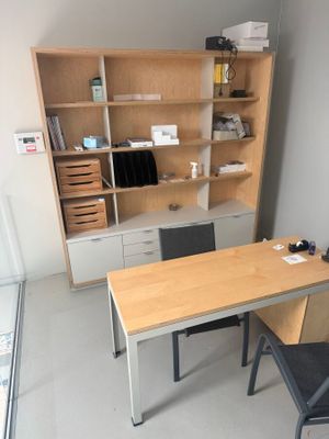 a desk with a chair and a bookcase in the corner