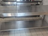 a stainless steel table in a kitchen with a stove in the background