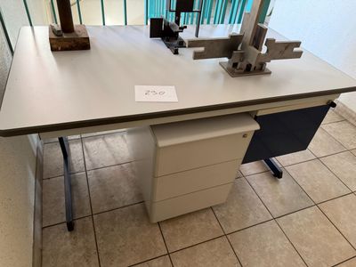 a desk with a computer on top of it in a room