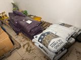 un lit dans une chambre où il y a beaucoup de sacs par terre