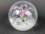 a glass ball with a flower inside of it on a table