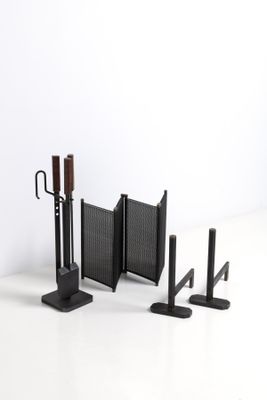 un ensemble de trois objets métalliques noirs posés sur une surface blanche