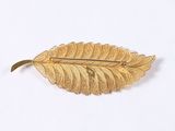leaf shaped brooch with gold leaf detail on a white background