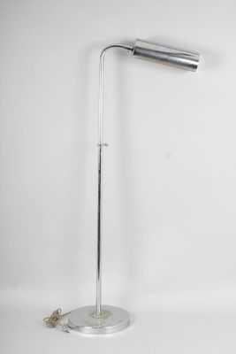 un lampadaire chromé avec un pied en métal et un fond blanc