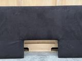 un oreiller noir posé sur une palette en bois