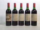 quatre bouteilles de vin sont alignées sur une surface blanche