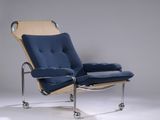 une image représentant une chaise avec un coussin bleu et des pieds chromés