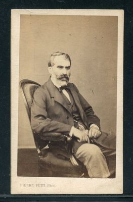 portrait d'un homme en costume-cravate, assis sur une chaise