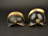 pair of helmets with gold accents on a black background