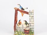 a picture of a ceramic figurine of birds on a well