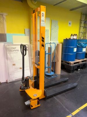un chariot élévateur dans un entrepôt, avec des palettes en arrière-plan
