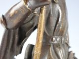 a bronze statue of a man riding a horse with a spear