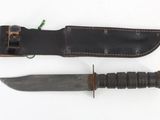a knife and a sheath on a white surface