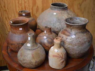 de nombreux vases posés sur une table, accompagnés d'étiquettes