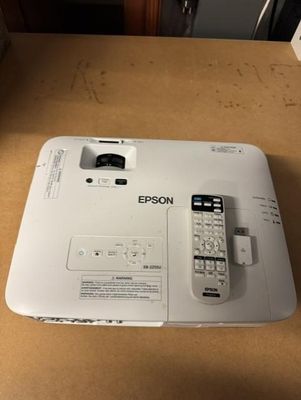 une photo montrant un projecteur blanc posé sur une table en bois