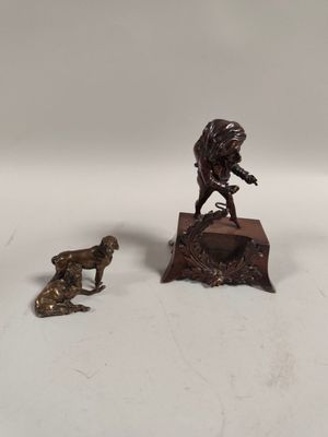 a bronze statue of a man and a dog on a table