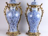 paire de vases bleus et blancs avec des anses et des couvercles dorés