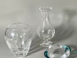 trois vases en verre posés sur une table l'un à côté de l'autre