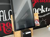 a tablet computer on a desk with a chalkboard behind it