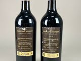 two bottles of red wine sitting next to each other on a table