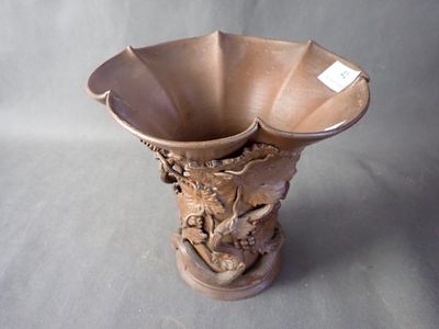 a brown vase with a dragon on it on a gray background
