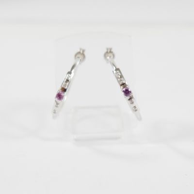 un gros plan d'une paire de boucles d'oreilles posées sur une surface transparente