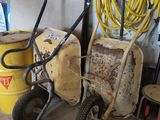 deux fûts jaunes et une brouette jaune dans un garage