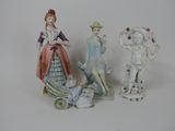 three figurines of people standing next to each other