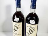 two bottles of wine sitting on top of a table next to each other