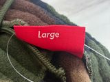 une étiquette rouge portant la mention « large » sur une veste de camouflage