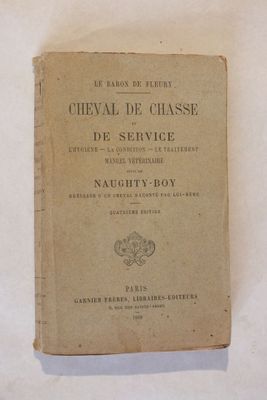un vieux livre posé sur une table blanche recouverte de papier