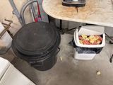 a trash can sitting next to a trash can on the floor