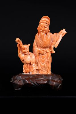 une image représentant une figurine sculptée d'un homme et d'un chat