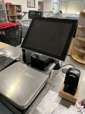 une photo représentant une caisse enregistreuse et un téléphone portable posés sur un comptoir