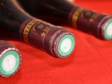 several bottles of wine are lined up on a red cloth